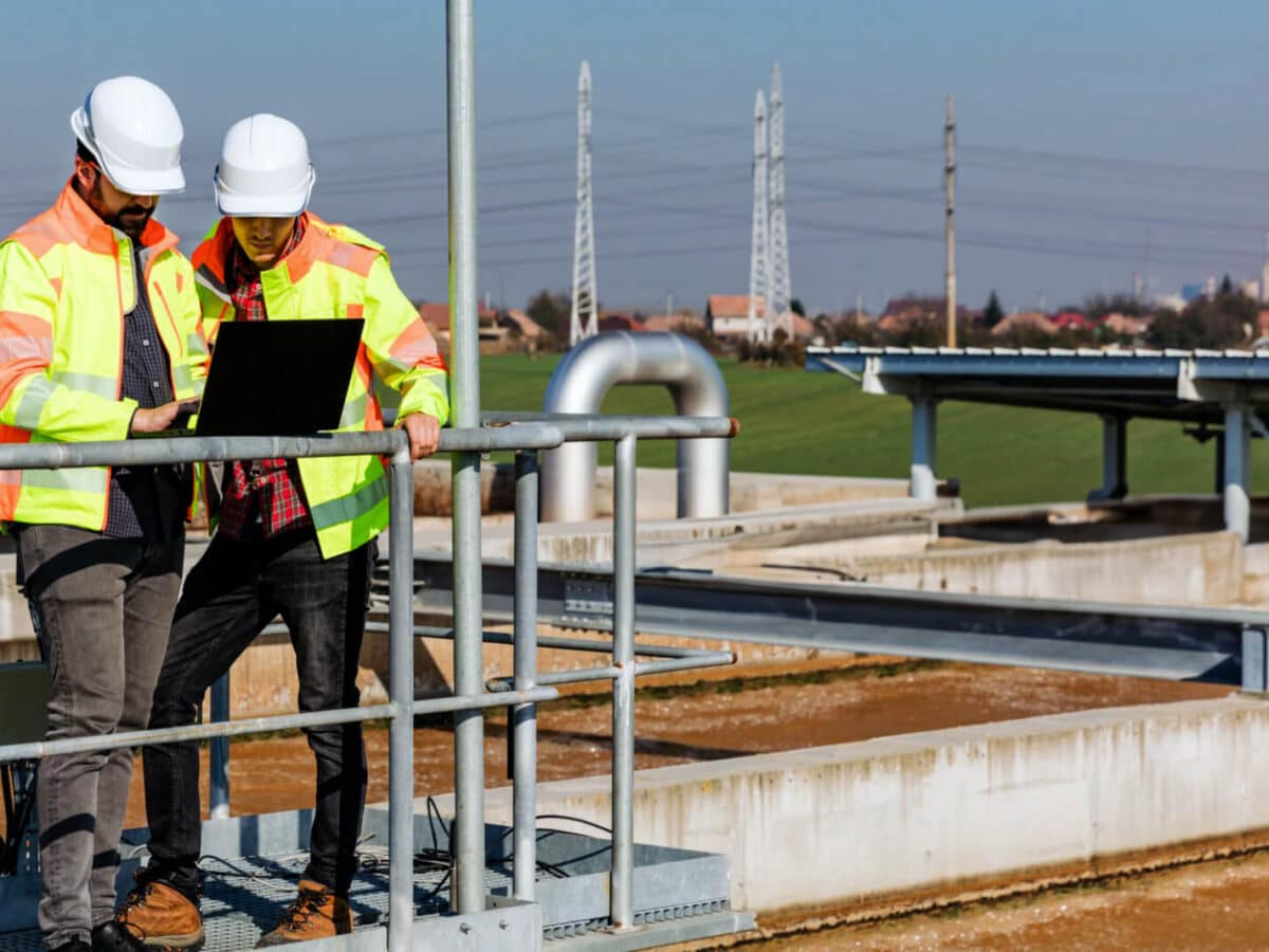 Two Wastewater Workers On Laptop